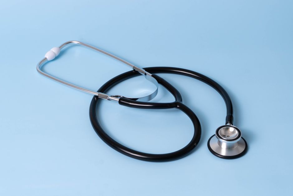 Close-up of a classic stethoscope on a blue background, symbolizing healthcare and medical profession.